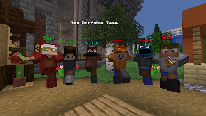 Sechs Rüstungsständer mit den Köpfen und Rüstungen des Dorfmine-Teams, jeder mit Armen und in einer eigenen Pose, darüber der Schriftzug „Das Dorfmine Team“.